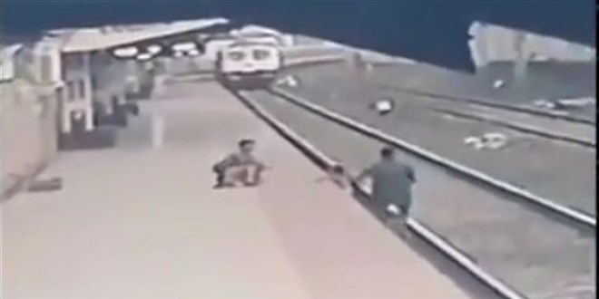 Raylara d��en �ocu�u trenin alt�nda kalmaktan son anda kurtard�